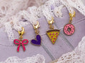 Close-up of the Slice Slice Baby Edit gold shoe charms on a lavender sneaker with lace laces