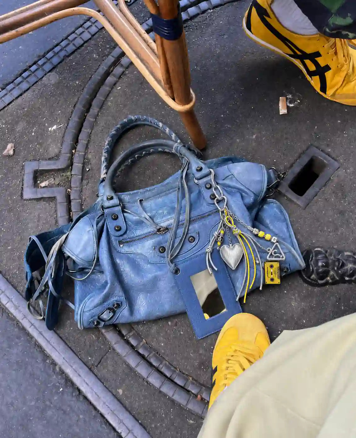 Chrome Pop Heart Bag Charm styled on a blue handbag with silver heart, yellow accents, cassette charm and chain details