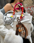 Dessert Date Chocolate Bag Charm styled on a white handbag with chocolate bar, ice cream, donut and heart charms