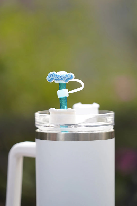 Pisces zodiac straw charm attached to a glittery blue straw in a white tumbler