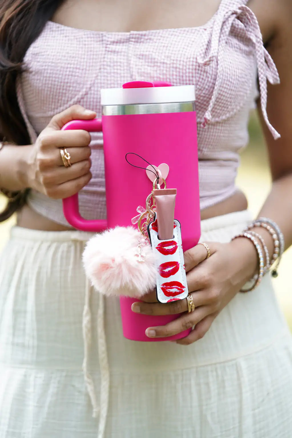 Close-up view of the Blush Butterfly Water Bottle Charm hanging from a pink handled tumbler with its butterfly, heart and pearl details visible