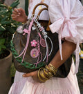 Blush Game Heart Bag Charm styled on a brown handbag with pink and silver cords, heart charms and mini tennis racket