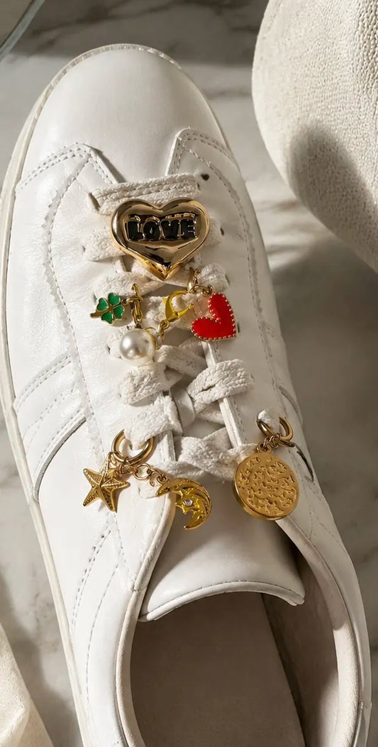 Charm’D AF Meet Cute Edit sneaker charms on white shoes featuring heart, pearl, star, moon, clover and gold decorative charms