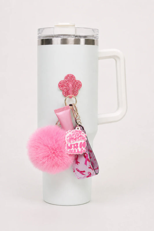 White handled tumbler with a pink glitter flower bottle hook holding accessories