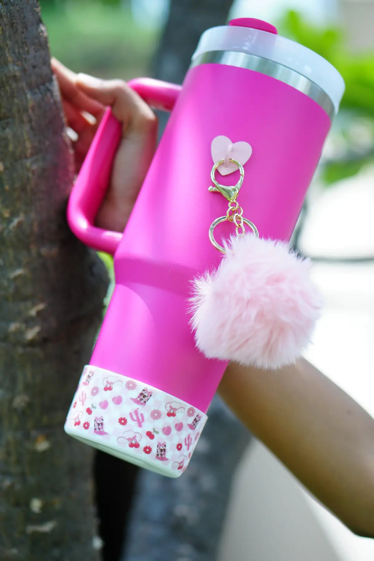 Cherry checker water bottle boot with pink and white cherry, flower, and decorative motifs, shown on a white background.