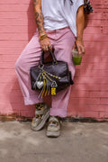 Chrome Pop Heart Bag Charm styled on a black handbag with metallic heart, yellow cassette charm and silver cords