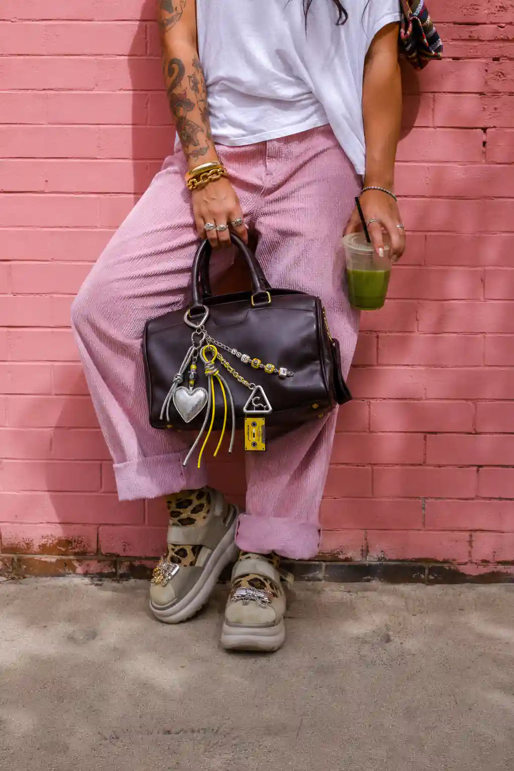 Chrome Pop Heart Bag Charm styled on a black handbag with metallic heart, yellow cassette charm and silver cords