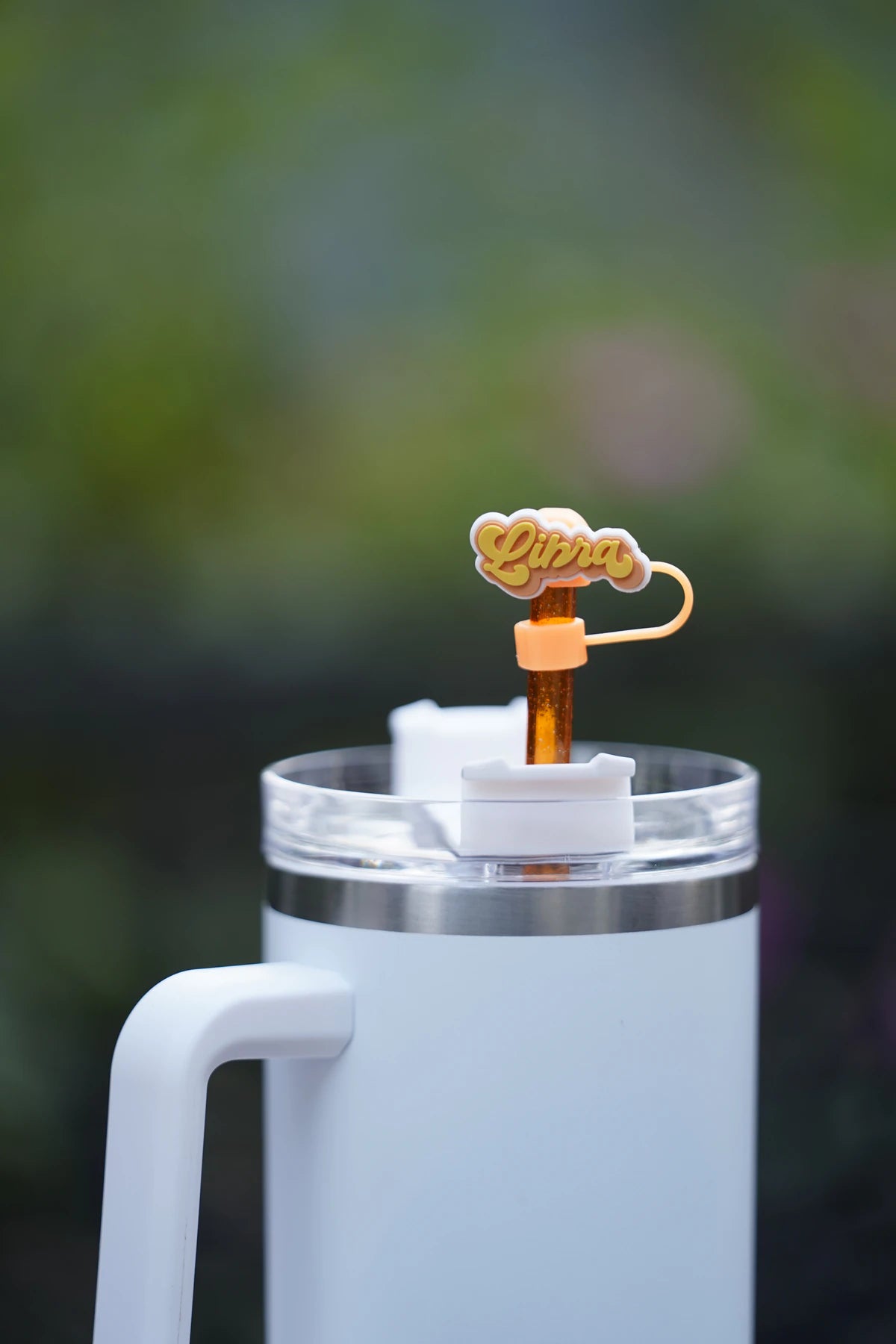 Libra zodiac straw charm attached to a glittery orange straw in a white tumbler