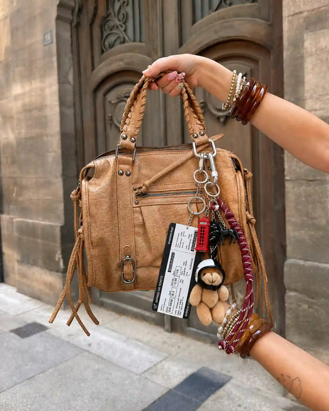 London Calling Teddy Bag Charm styled on a tan handbag with plush teddy, boarding pass, red phone booth and layered cords