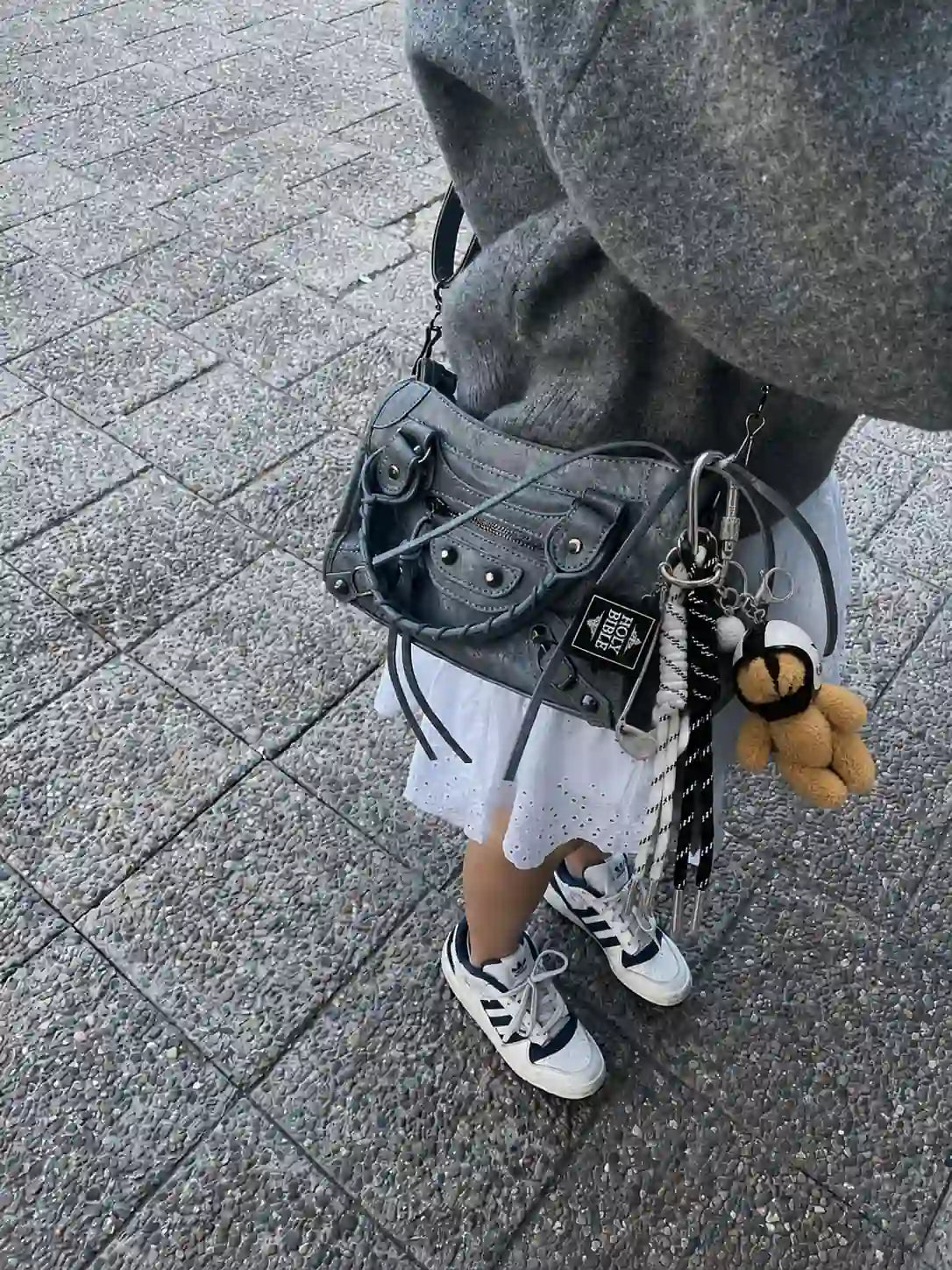 Metro Muse Teddy Bear Bag Charm styled on a grey handbag with plush teddy, golf-inspired charms and black and white cords
