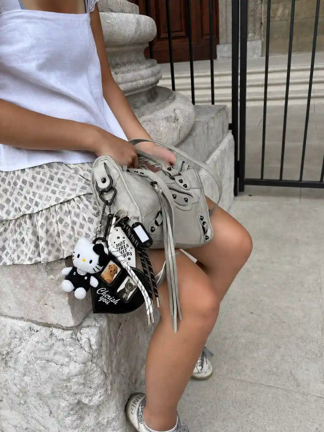Midnight Album Kitty Bag Charm styled on a grey handbag with plush kitty, heart charm and black white cords