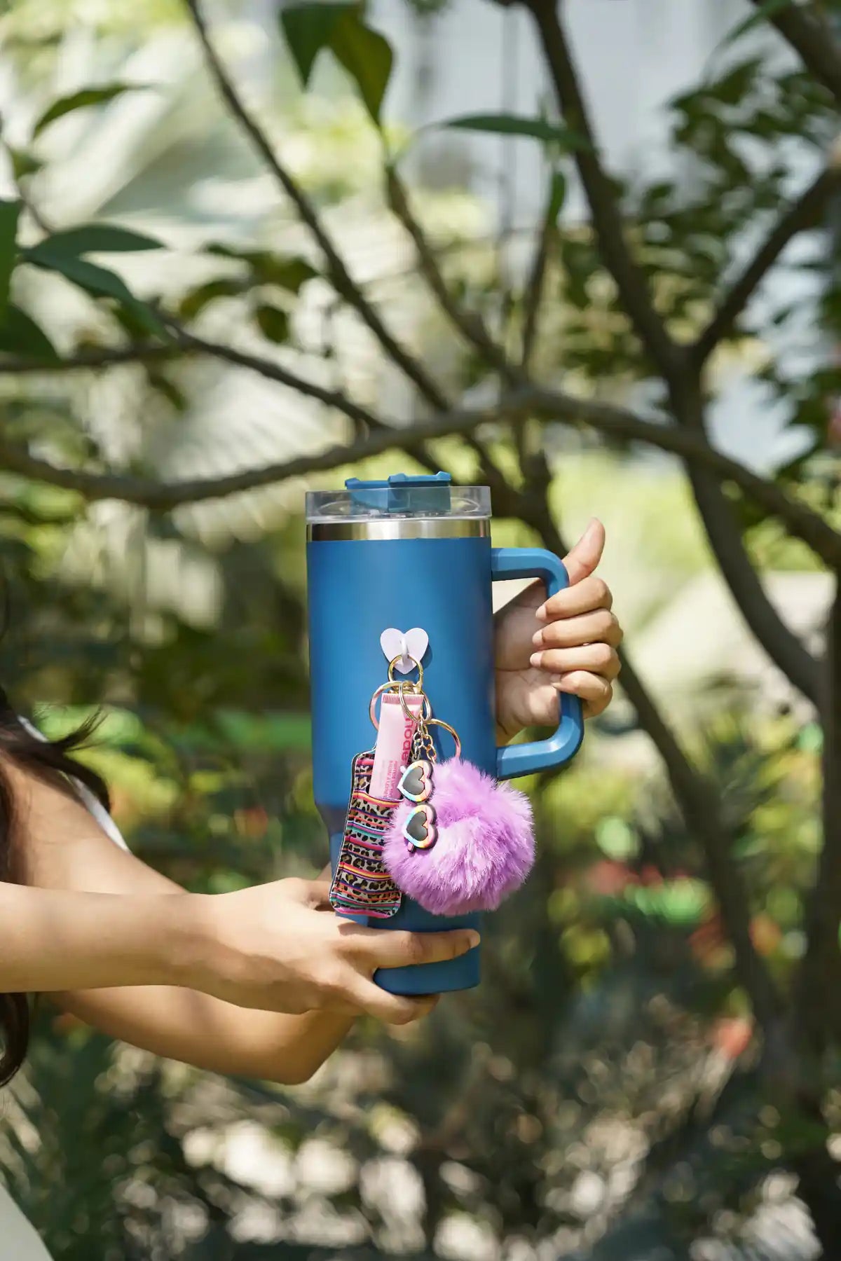 Neon Safari Pop Lip Balm Holder attached to a blue tumbler with a pink lip balm and fluffy purple pom pom charm