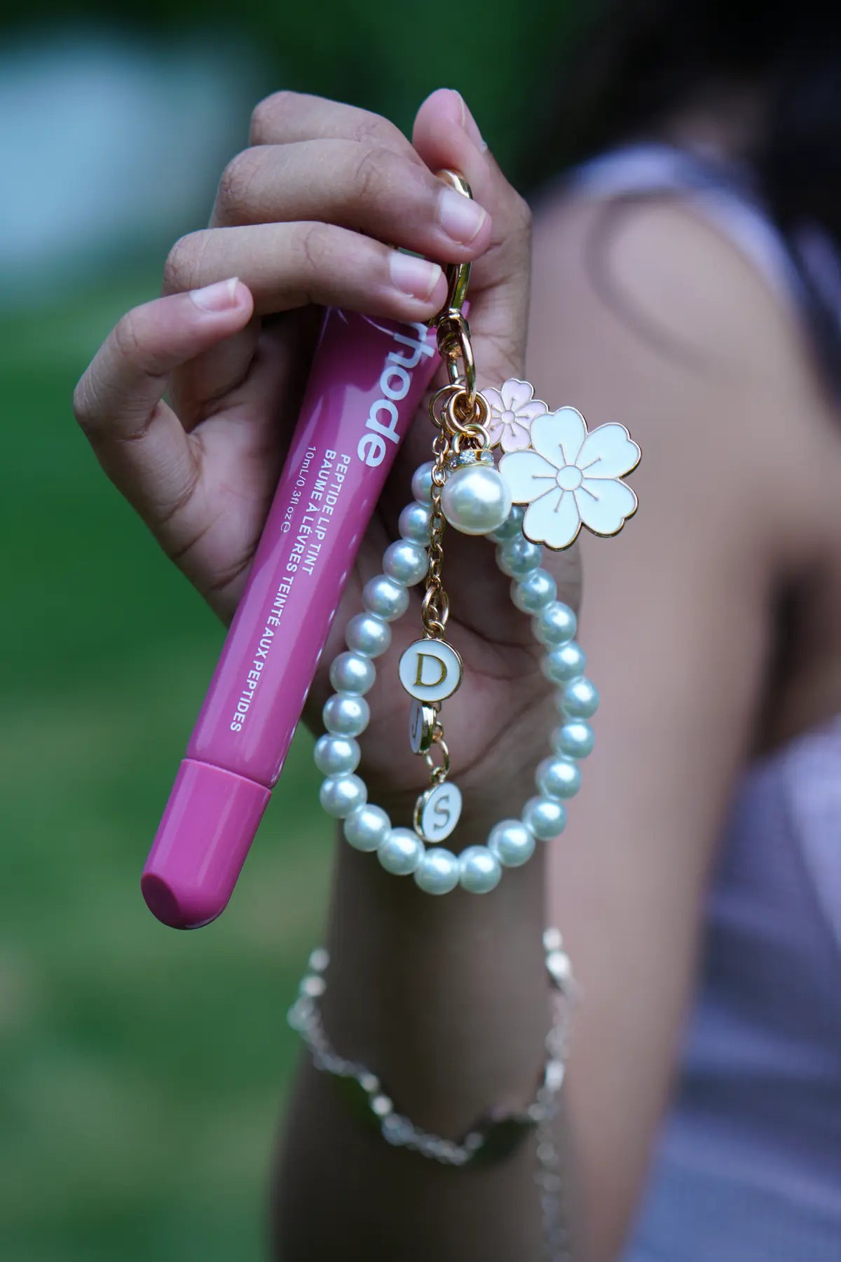 Close-up of pearl heart lip balm charm attached to a pink lip balm tube