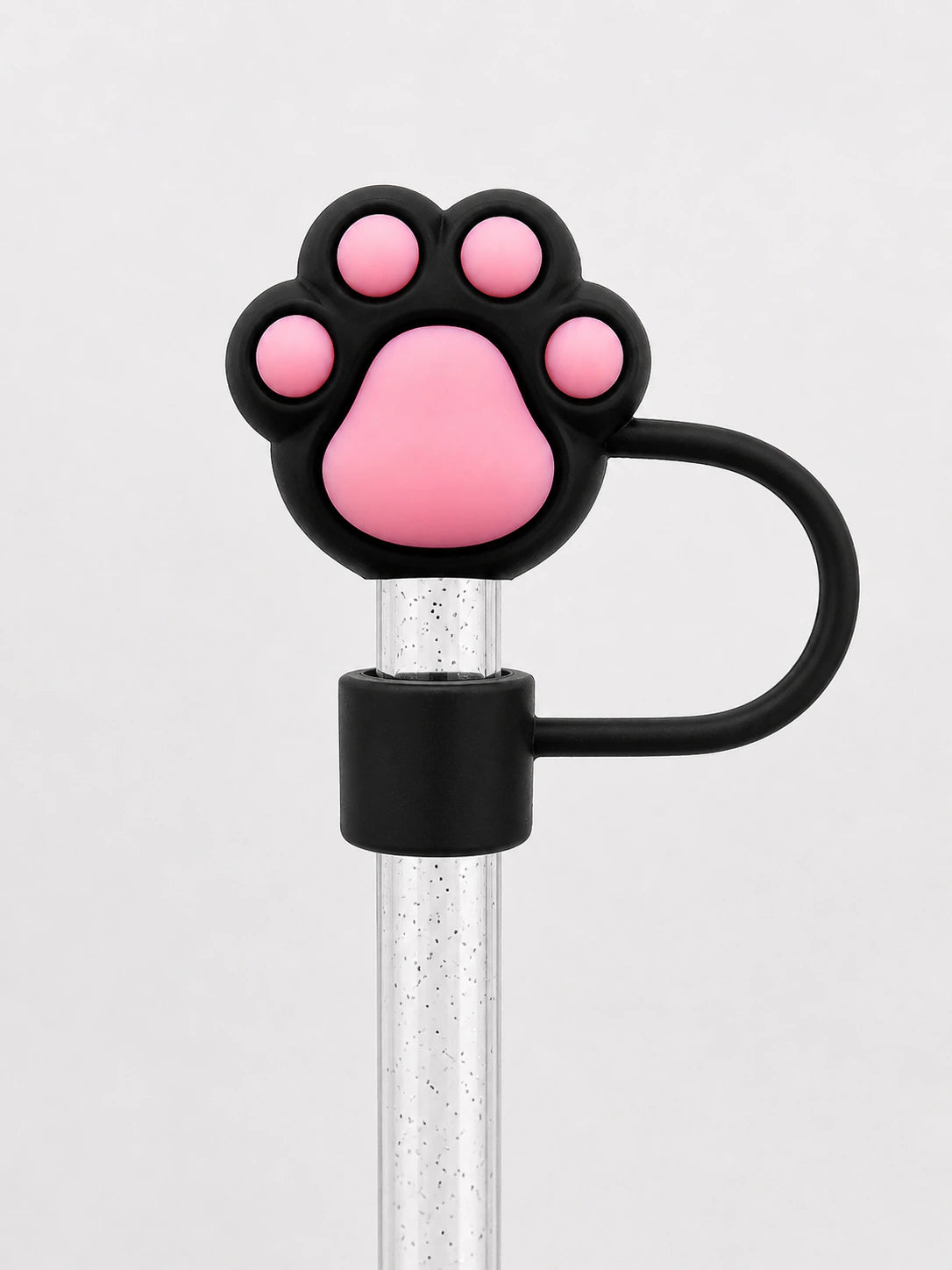 Black and pink paw print straw charm attached to a clear reusable straw