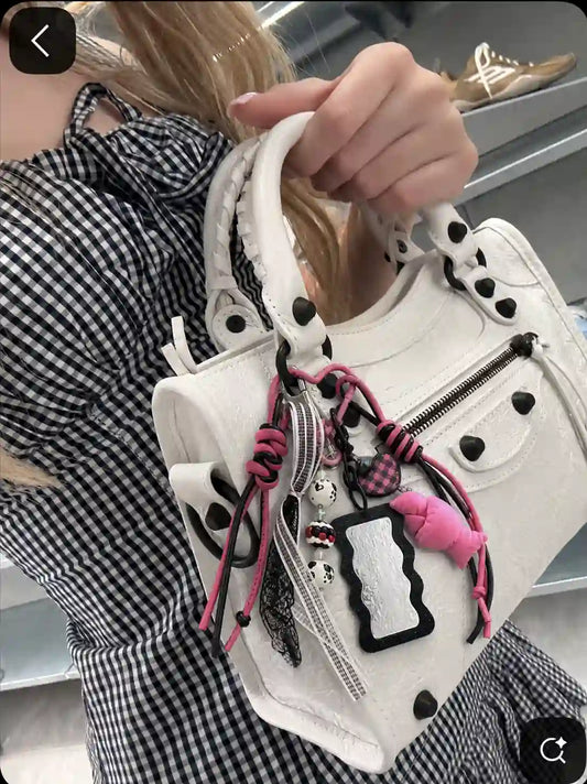 White handbag styled with the Pink Rebel Drop croissant bag charm