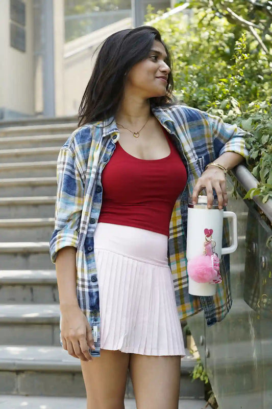 Woman holding a white tumbler decorated with a pink pom pom, pink ribbon lip balm holder and Let's Go Girls charm