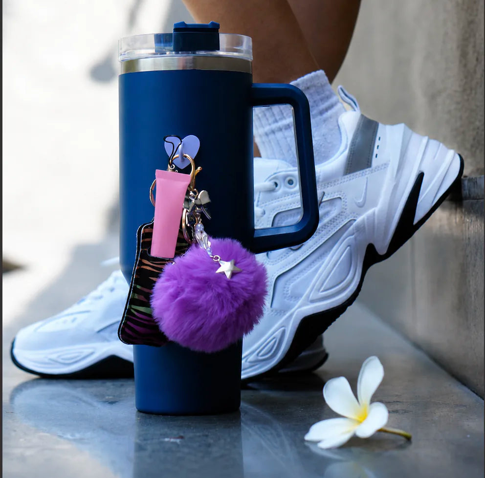 Starbow Heart Water Bottle Charm displayed on a blue water bottle beside a woman outdoors
