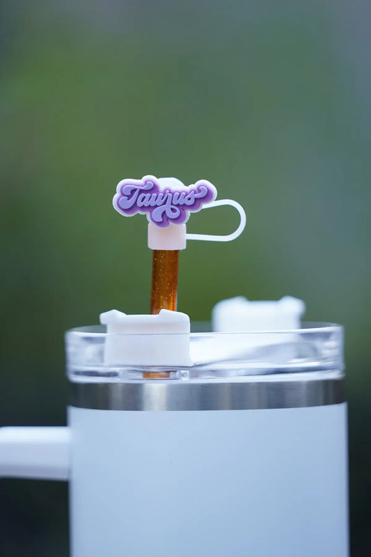 Taurus zodiac straw charm attached to a glittery orange straw in a white tumbler