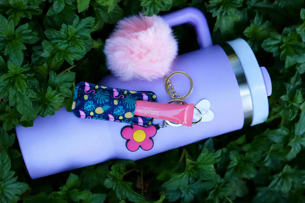 Tropical Flamingo Vibes Lip Balm Holder attached to a lavender tumbler with pink lip balm and fluffy pom pom