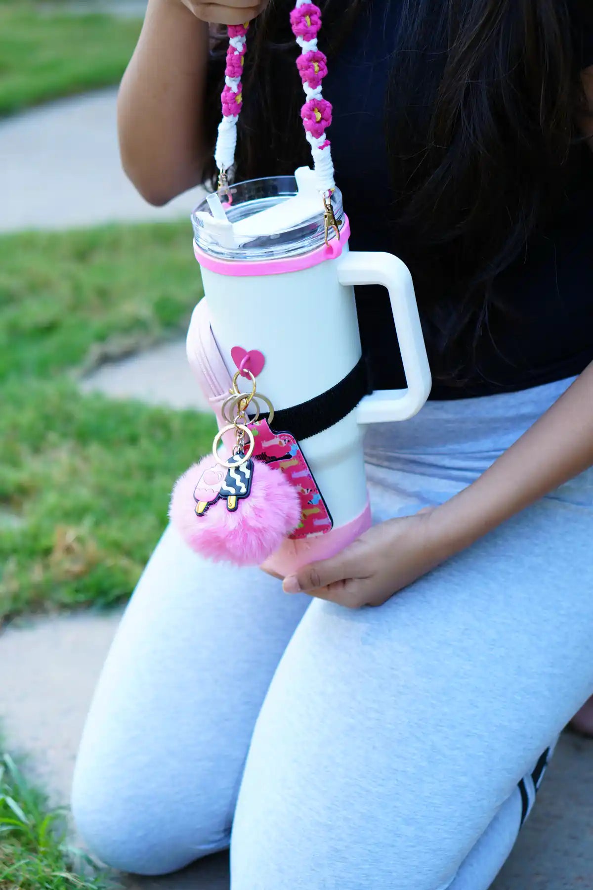 Ultimate IT Girl Pink Bundle styled on a white water bottle with floral strap, pink pouch, heart and popsicle charms and fluffy pom pom