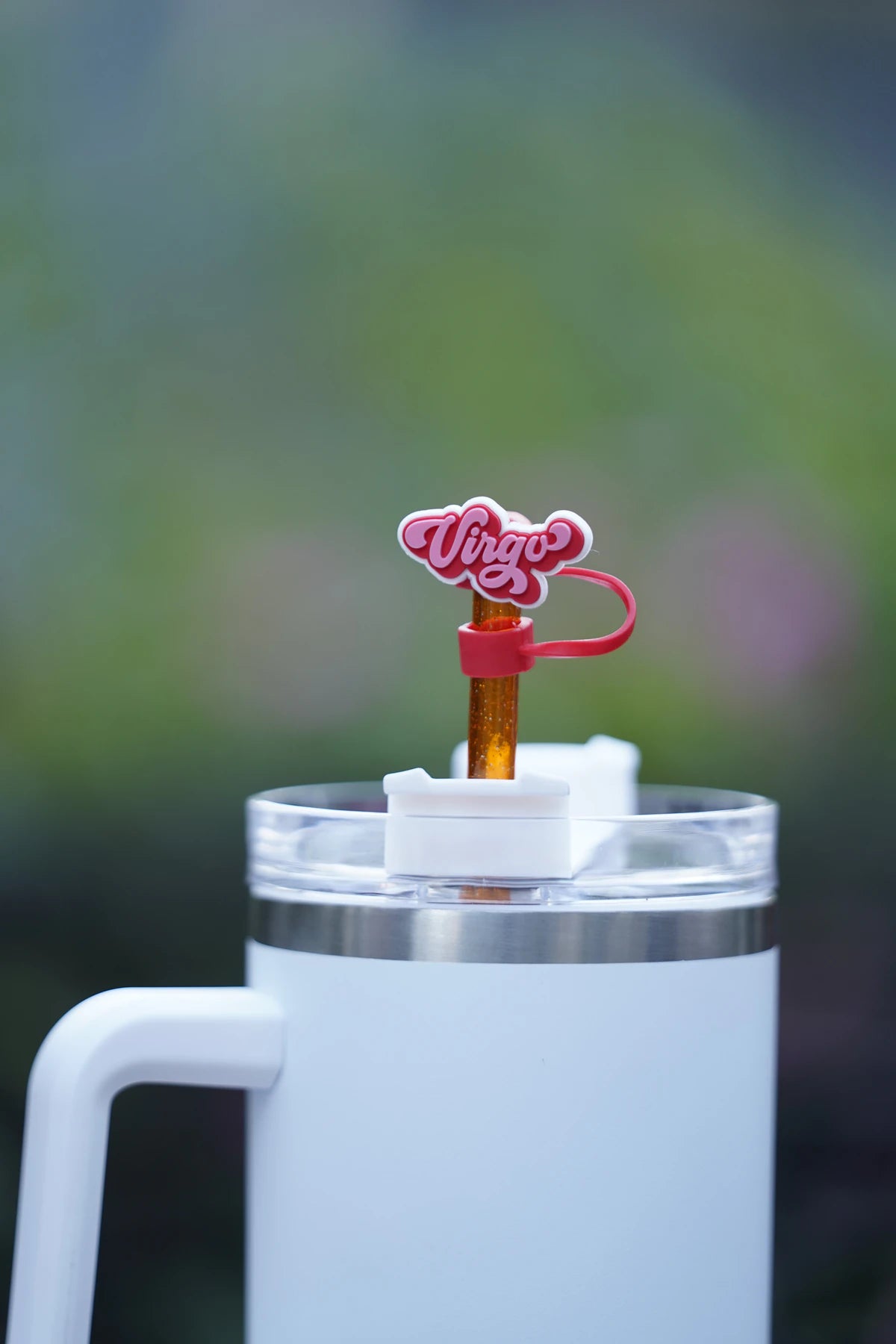 Virgo zodiac straw charm attached to a glittery orange straw in a white tumbler
