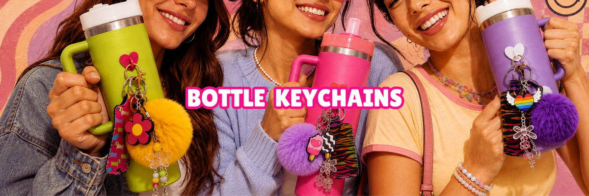 Charm'D AF colourful bottle keychains with playful charms and fluffy pom poms styled on water bottles